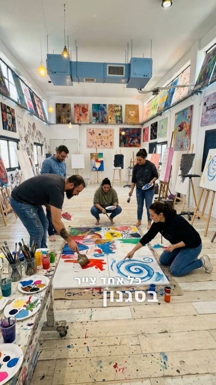 צוות מצייר על קנבס גדול על רצפת הסטודיו